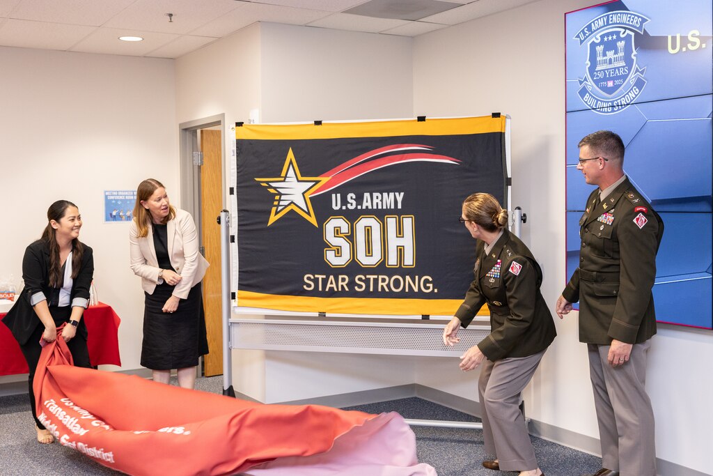 4 people pull unveil the Army Star flag.
