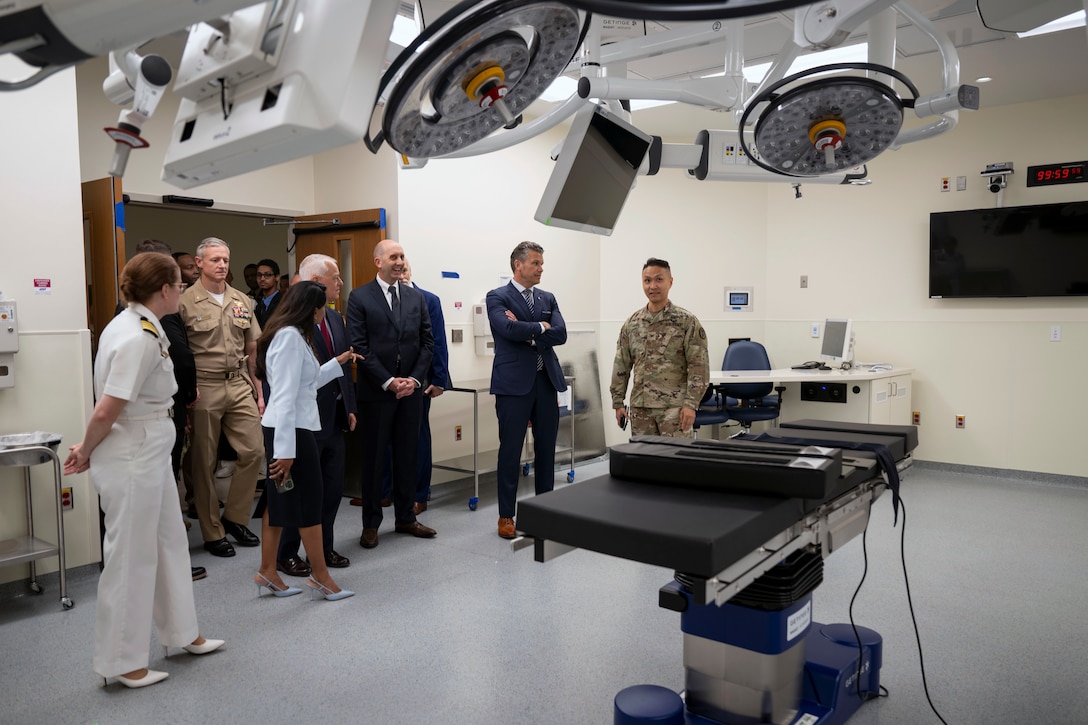 The defense secretary tours a hospital with a group of people.