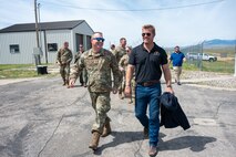 A man in uniform walks with a man in civilian attire.
