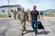 A man in uniform walks with a man in civilian attire.