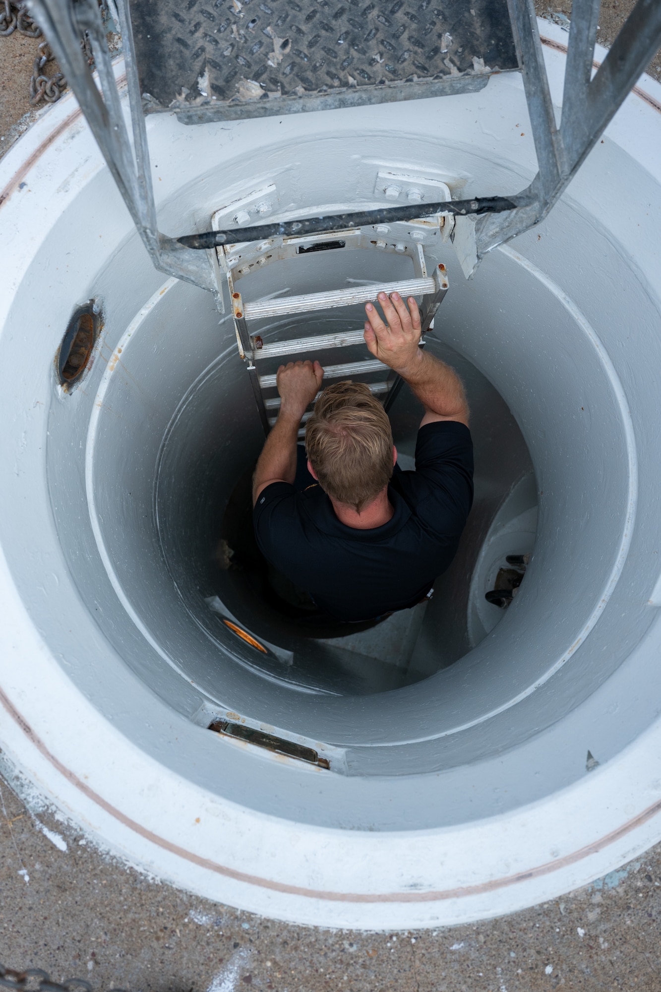 A man in civilian attire climbs down a ladder.