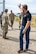 A man in civilian attire waves behind him.