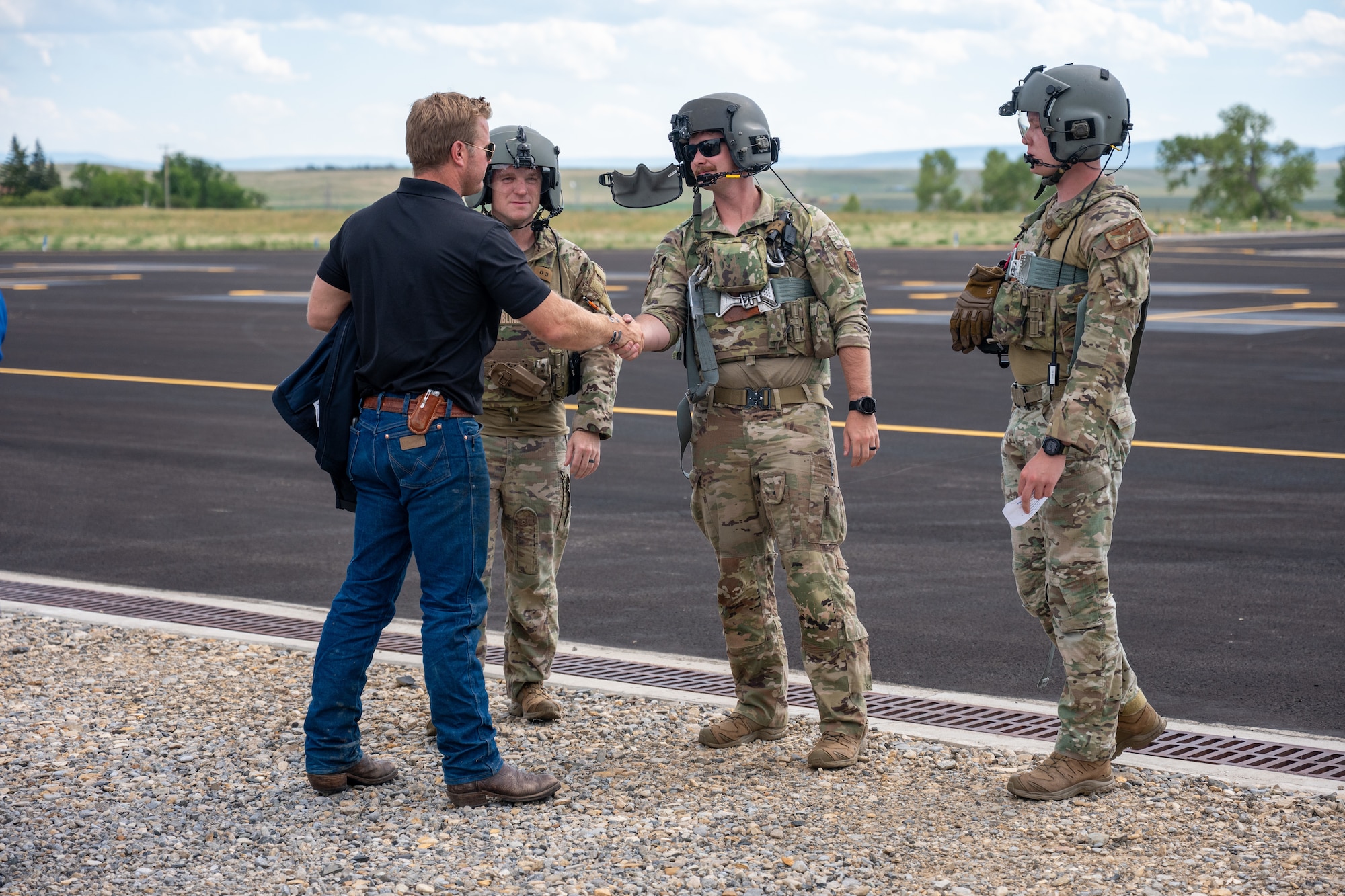 A man in civilian attire shakes hands with a man in uniform.