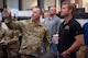 A man in uniform points something out to a man in civilian attire.