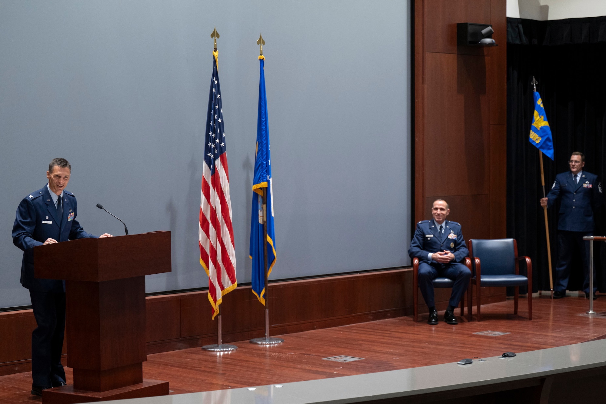 Col. Jared Broddrick, commander of the 71st Surveillance Squadron, gives opening remarks during the squadron’s activation ceremony Aug. 1, 2025.  The 71st SURS will be responsible for augmenting the 22nd Surveillance Squadron by providing strategic surge capacity and steady-state mission requirements in support of AFTAC’s global nuclear surveillance mission.  The 22nd SURS operates AFTAC’s 24-hour operations center that collects, processes and analyzes information from a global seismic, hydroacoustic, satellite and radio frequency recording network.  Also pictured is (seated) Col. David Sawyer, deputy commander of the 655th Intelligence, Surveillance and Reconnaissance Wing and presiding official for the ceremony and Master Sgt. Joshua D. Hauser, 71st SURS First Sergeant.  (U.S. Air Force photo by Matthew S. Jurgens)