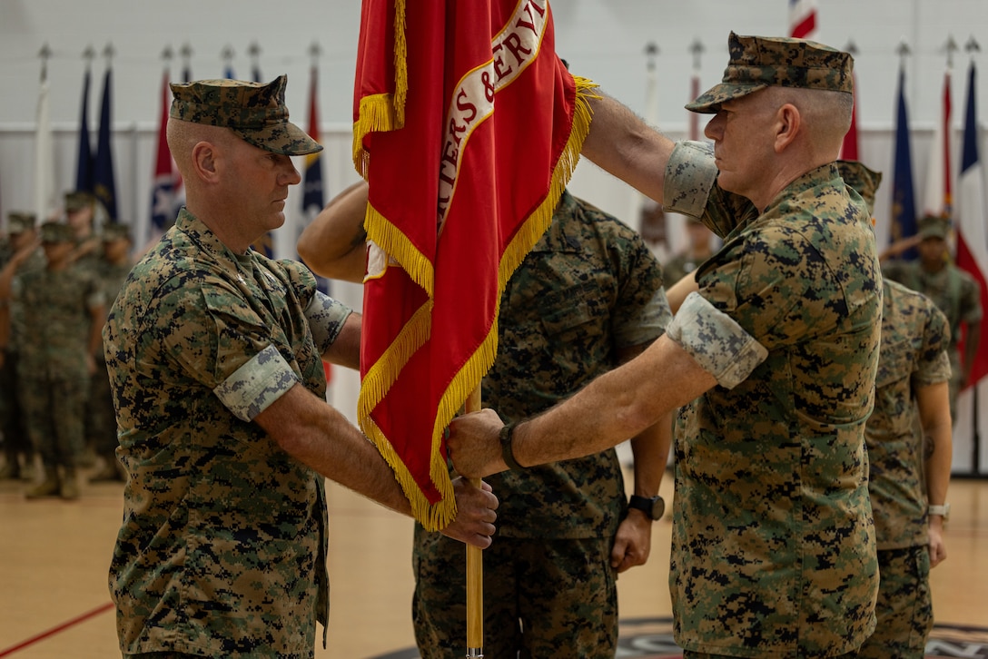 U.S. Marine Corps Col. Michael C. Rock, incoming commanding officer, Headquarters & Service Battalion, Fleet Marine Force, Atlantic, Marine Forces Command, Marine Forces Northern Command receives the colors from Col. Daniel T. Celotto, outgoing commanding officer, HQSVCBN, MARFORCOM, during a change of command ceremony at Camp Elmore, Virginia, July 10, 2025. The change of command ceremony is a military tradition that signifies all responsibilities and authorities are being transferred from one commanding officer to another. (U.S. Marine Corps photo taken by Corporal Catherine S. Verenzuela Mariano)