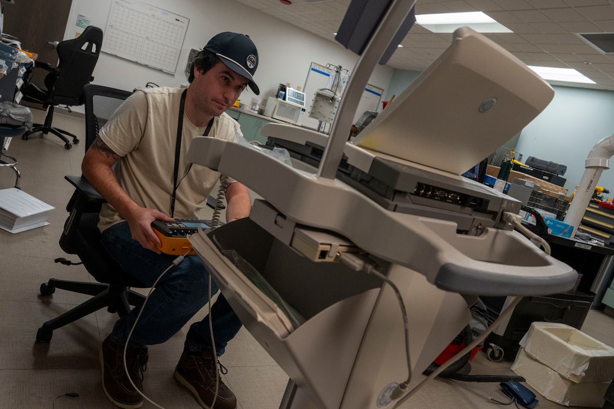 Man sit while working on EKG machine