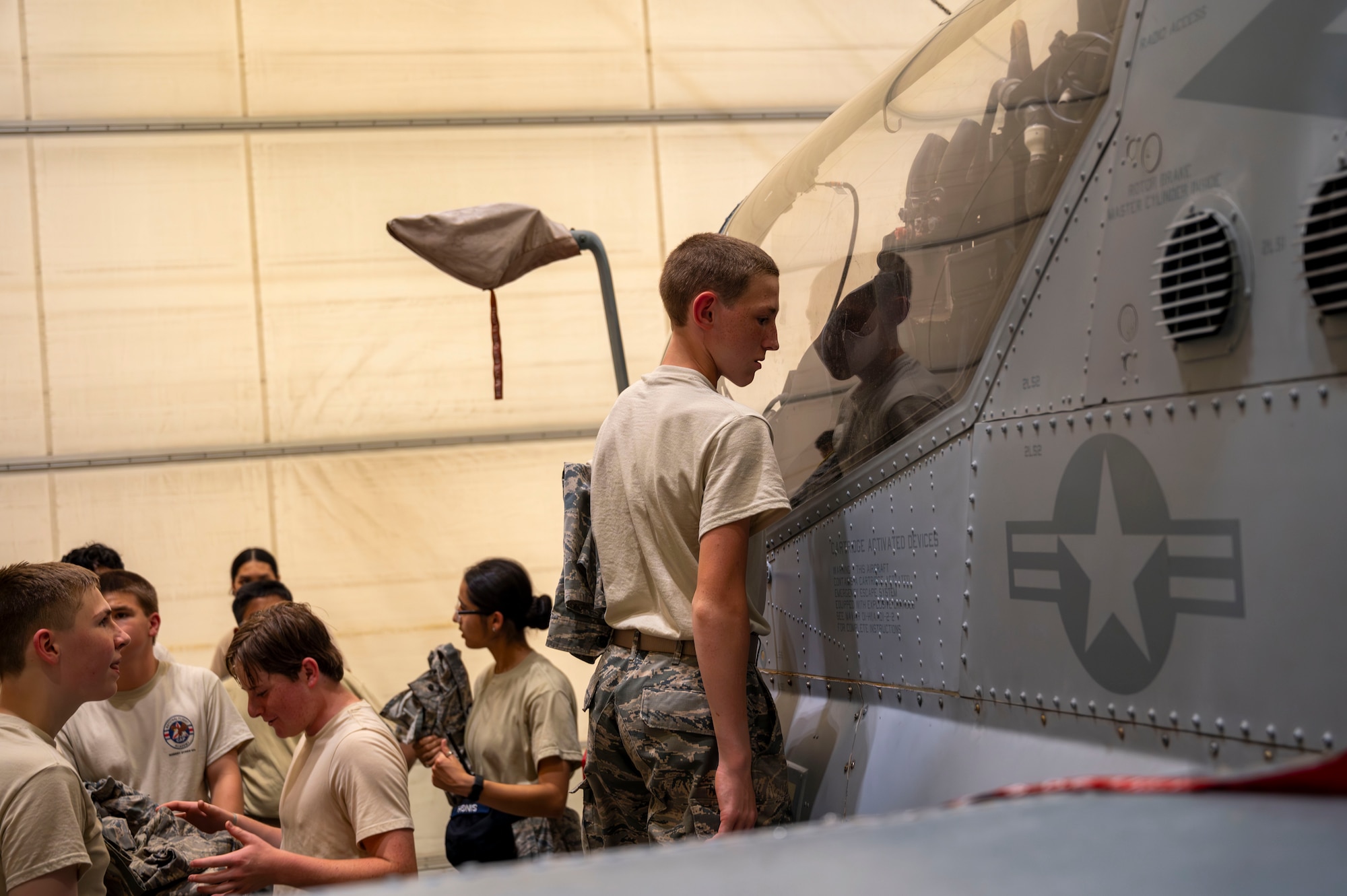 A Civil Air Patrol cadet views the cockpit of an AH-1Z Viper helicopter within the Marine Aircraft Group 49 hangar during the 2025 NJ Wing Basic Encampment at Joint Base-McGuire-Dix-Lakehurst, N.J., July 30, 2025.  The week-long encampment aimed to strengthen the cadets’ leadership skills, hone their fitness and character, and prepare them for future career opportunities in aerospace and technology. (U.S. Air Force photo by Susan Moriarty)