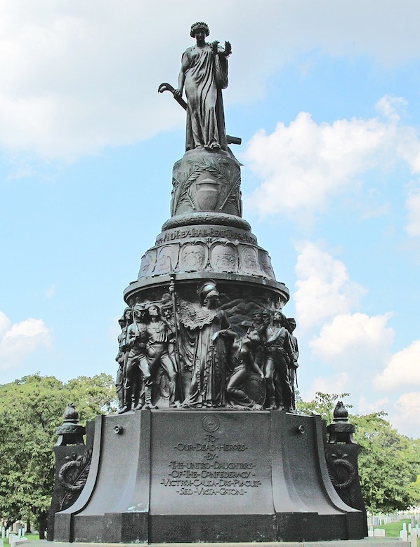 A large metallic statue is adorned with a lady on top and warriors near the bottom.