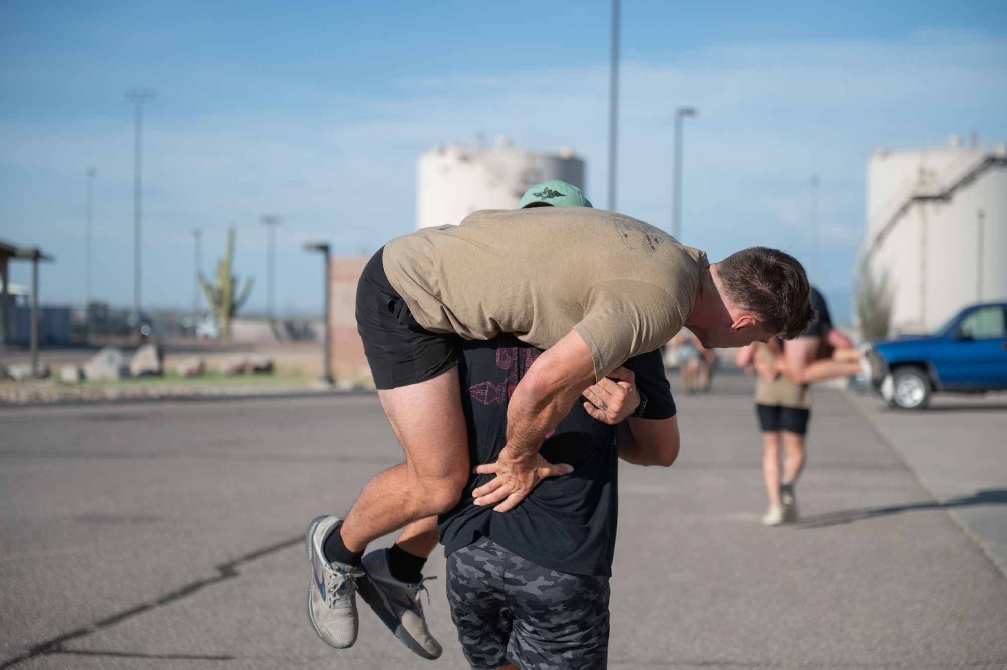 U.S. Airmen from the 48th Rescue Squadron perform a buddy carry during a memorial workout at Davis-Monthan Air Force Base, August 6, 2025. This exercise was part of a memorial workout in memory of the 31 fallen U.S. service members of Extortion 17 and showed DM’s commitment to readiness and lethality. (U.S. Air Force photo by Airman Jaden Kidd)