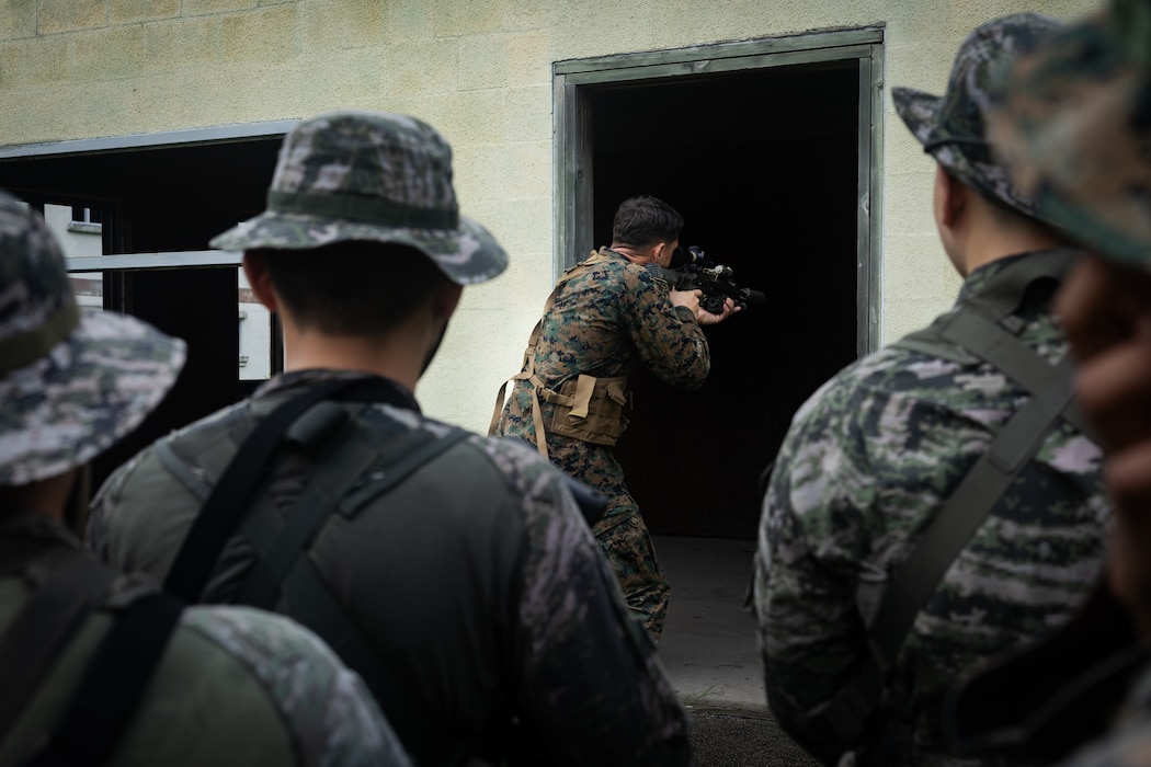 U.S. Marine Corps Sgt. Matthew Roderick, a squad leader with 2nd Battalion, 23rd Marines, forward deployed with 4th Marine Regiment, 3d Marine Division as part of the Unit Deployment Program, demonstrates to Republic of Korea Marines entry techniques during military operations in urban terrain training during the Korean Marine Exchange Program 25.2 in Pocheon, South Korea, July 22, 2025. KMEP is conducted regularly between the ROK and U.S. Marine Corps to increase their combined capabilities through realistic training geared towards deterring threats and maintaining peace in the Indo-Pacific. (U.S. Marine Corps photo by Lance Cpl. Van Hoang)