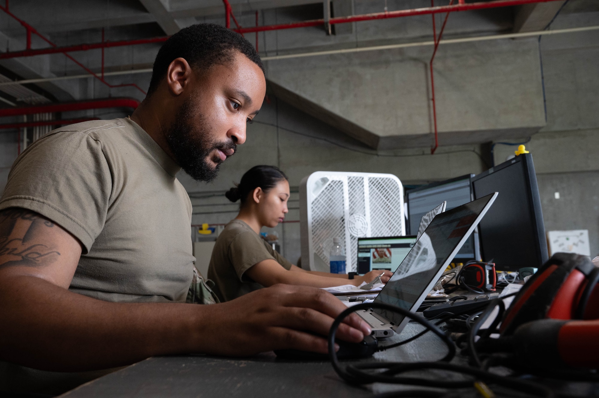 Two service members use computer.