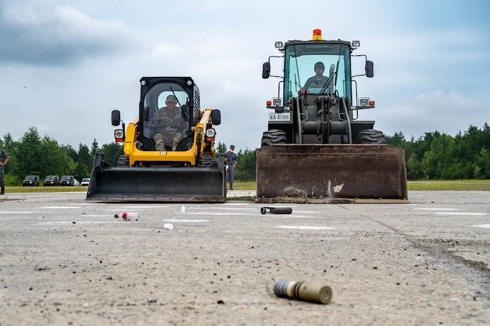 U.S. Air Force Airman 1st Class Michael Kowalski, left, 18th Civil Engineer Squadron heavy equipment operator, and a Japan Air Self Defense Force airman assigned to the 2nd Air Wing, utilize heavy machinery to perform unexploded ordnance clearing procedures during exercise Resolute Force Pacific 2025 while conducting Rapid Airfield Damage Repair training at Chitose Air Base, Japan, July 28, 2025.