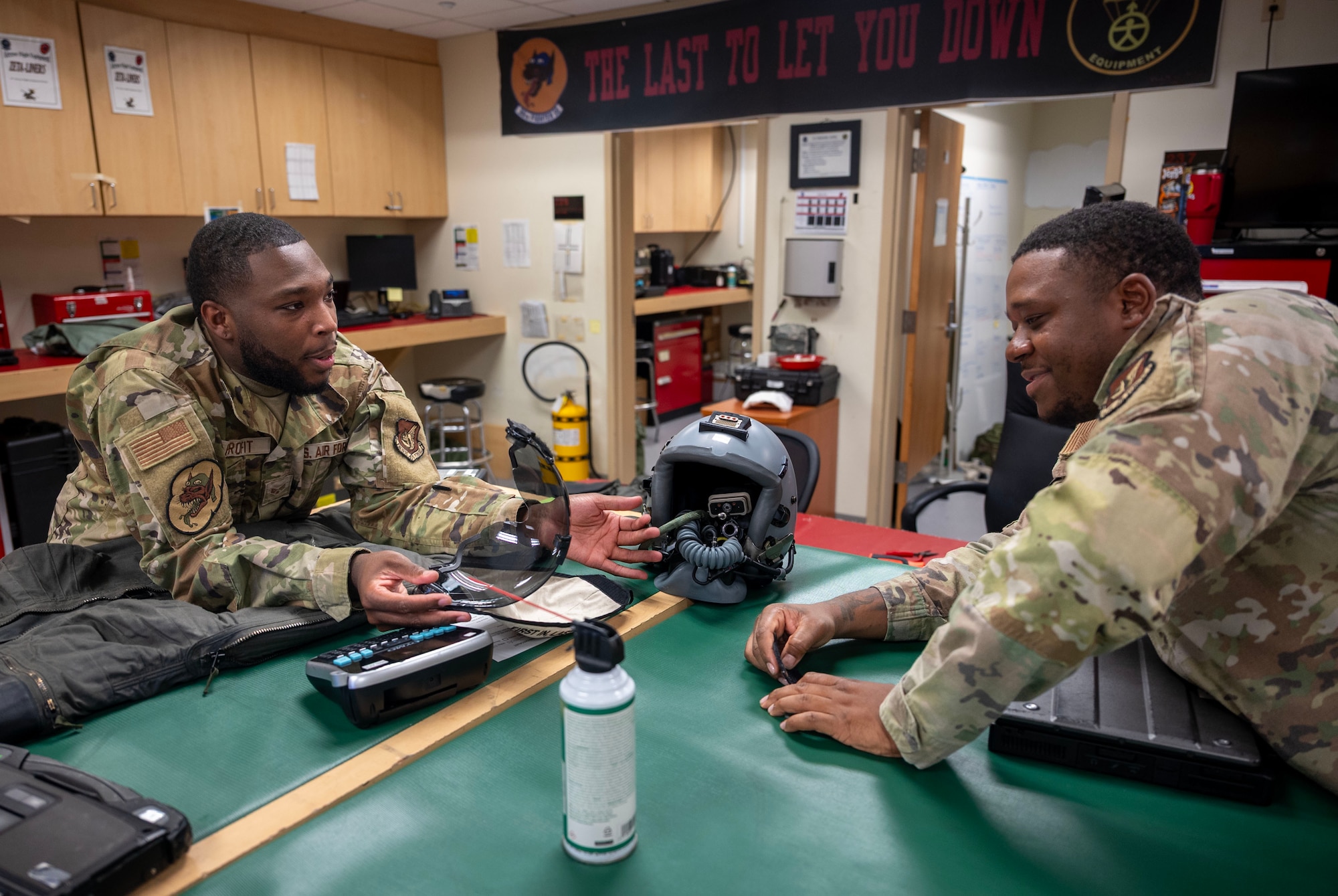 U.S. Air Force Senior Airman Tyreik Profit, left, 51st Operational Support Squadron aircrew flight equipment technician, explains the use of a helmet visor at Osan Air Base, Republic of Korea, Aug. 5, 2025. Profit and his team managed aircraft-installed equipment such as the Advanced Concept Ejection Seat II survival kit and personnel recovery parachutes. (U.S. Air Force photo by Staff Sgt. Sarah Williams)