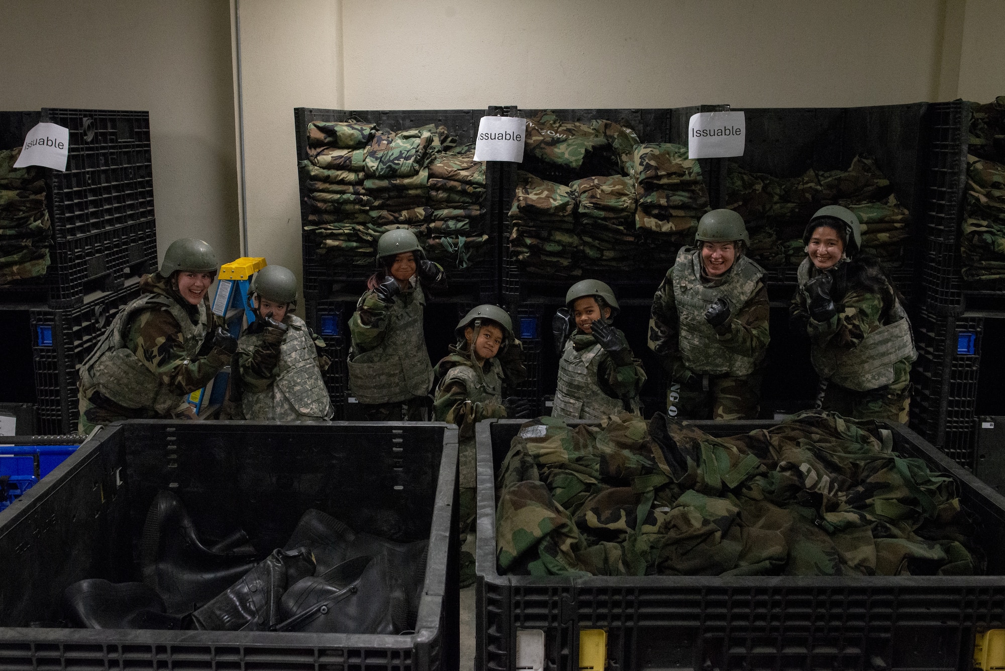 Airmen and family members pose for a picture in MOPP gear.