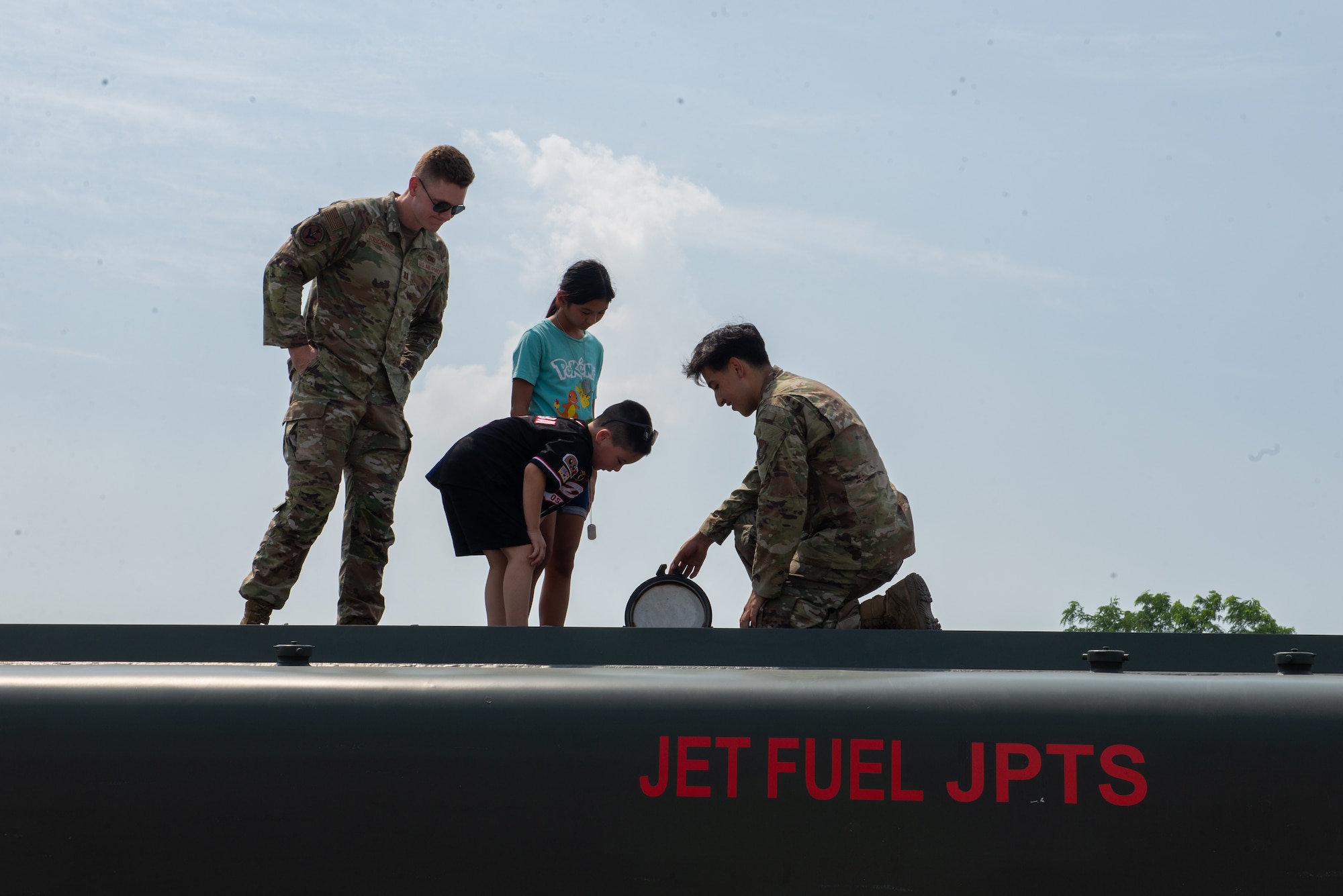 Airmen show children the inside of a fuel truck.
