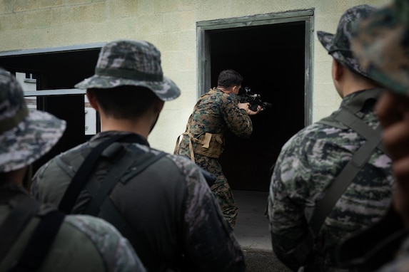 U.S. Marine Corps Sgt. Matthew Roderick, a squad leader with 2nd Battalion, 23rd Marines, forward deployed with 4th Marine Regiment, 3d Marine Division as part of the Unit Deployment Program, demonstrates to Republic of Korea Marines entry techniques during military operations in urban terrain training during the Korean Marine Exchange Program 25.2 in Pocheon, South Korea, July 22, 2025. KMEP is conducted regularly between the ROK and U.S. Marine Corps to increase their combined capabilities through realistic training geared towards deterring threats and maintaining peace in the Indo-Pacific. (U.S. Marine Corps photo by Lance Cpl. Van Hoang)
