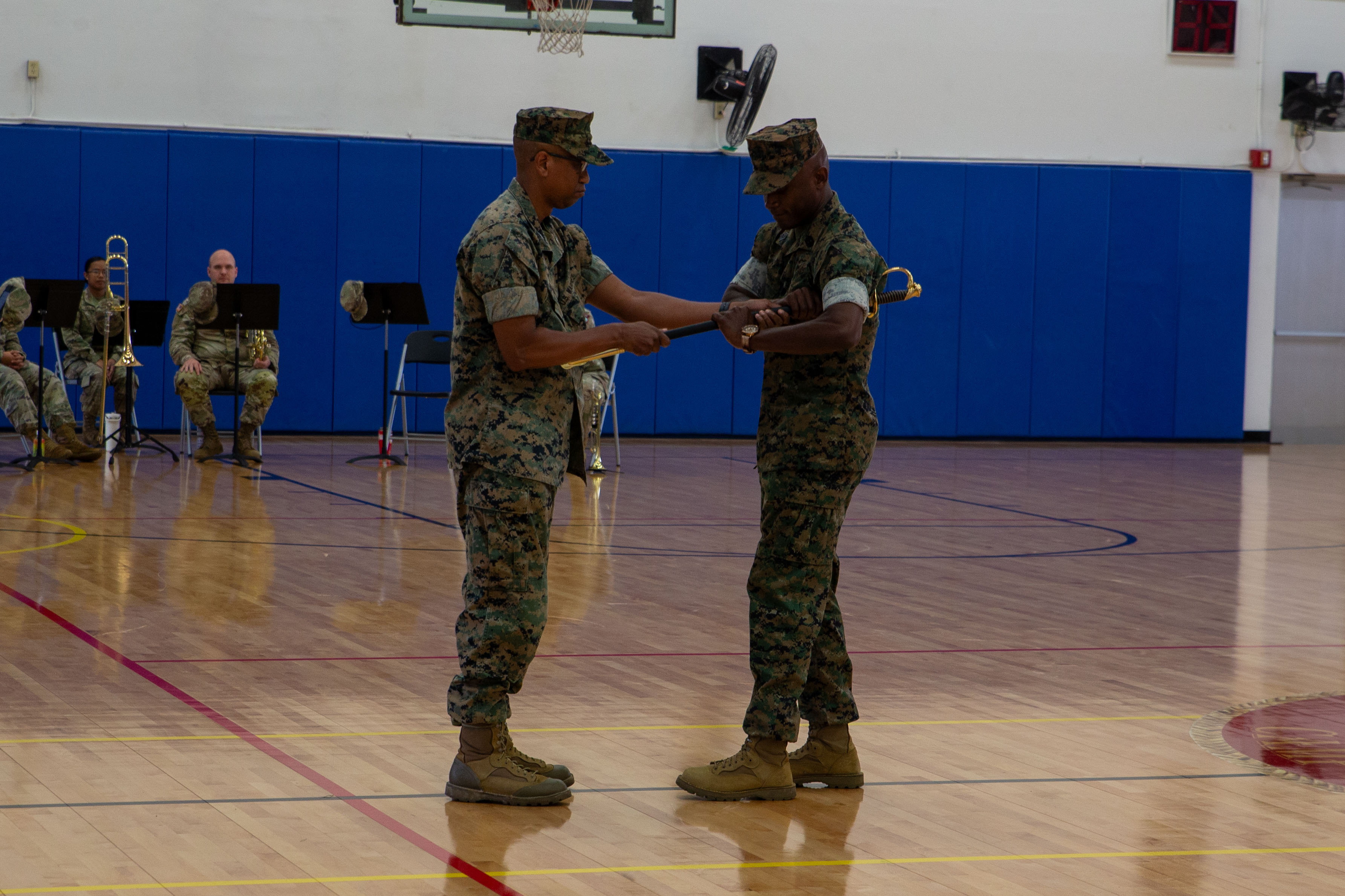 U.S. Marine Corps Col. Richard D. Marshall Jr, commanding officer, Marine Corps Base Camp Blaz, passes the Sword of Office to Sgt. Maj. Robert E. Catching, oncoming senior enlisted leader of MCB Camp Blaz, during an appointment ceremony on Marine Corps Base Camp Blaz, Guam, Aug. 8, 2025. Sgt. Maj. Catching will serve as the bases second sergeant major since its official activation in 2020. (U.S. Marine Corps photo by Lance Cpl. Afton Smiley)