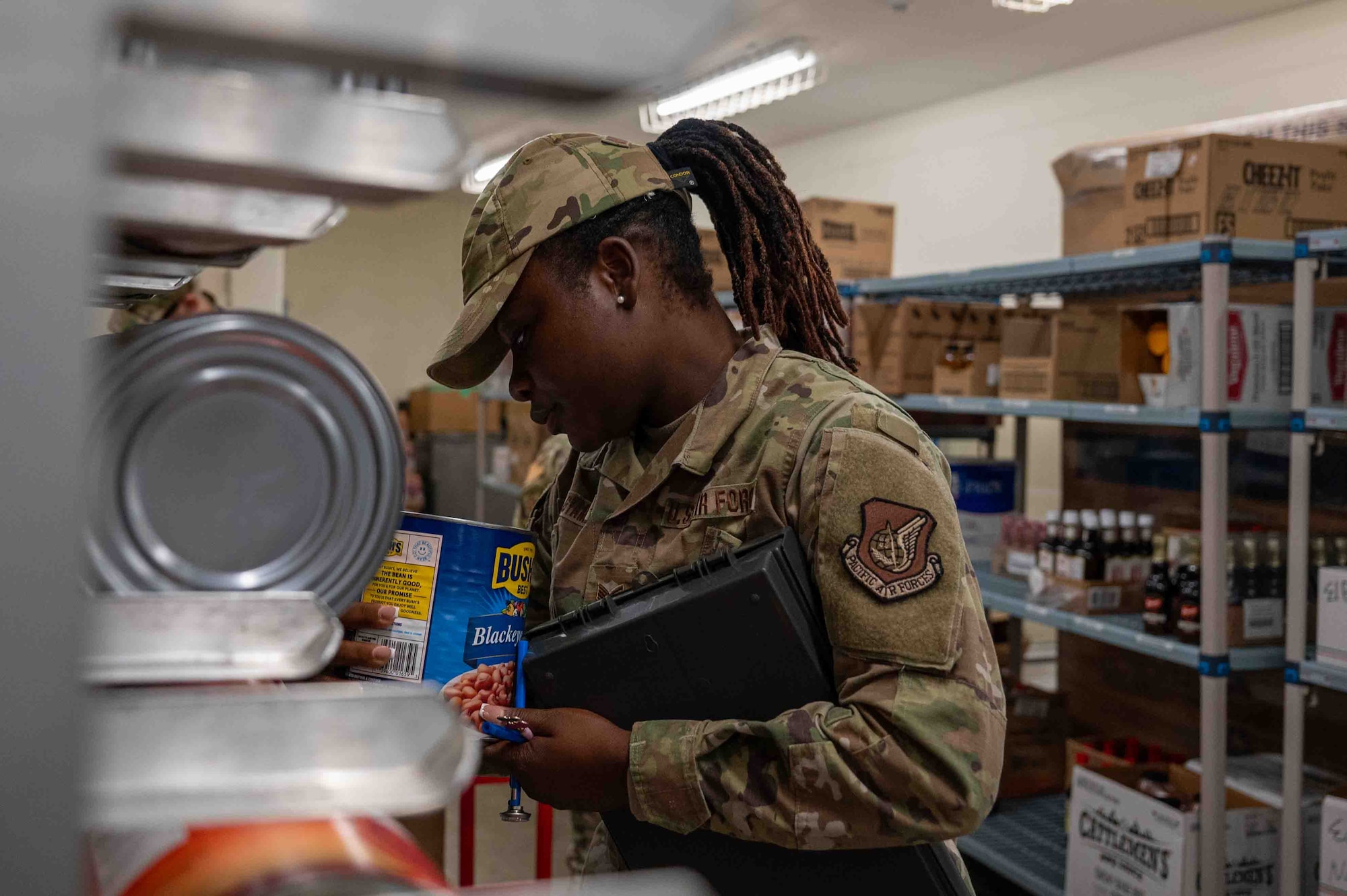 U.S. Air Force Staff Sgt. Afua Kwenua Dwiredu Gyamera, 18th Operational Medical Readiness Squadron non-commissioned officer in charge of community health, checks for the expiration date on the canned food on Kadena Air Base, Japan, Aug. 4, 2025.