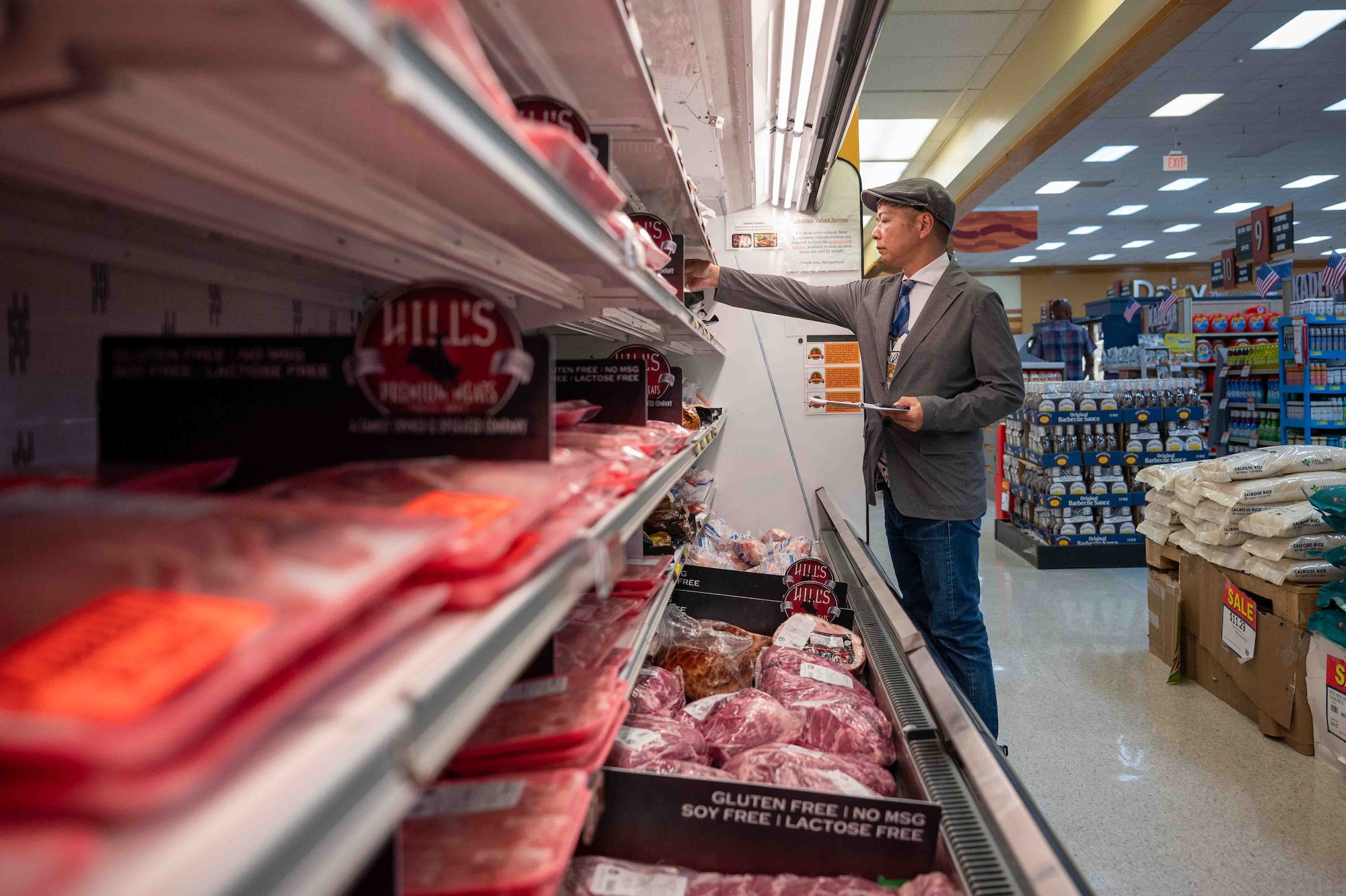 Masayuki Sakugawa “Mr. Mabo”, 18th Operational Medical Readiness Squadron public health food inspector, grabs an item from a shelf on Kadena Air Base, Japan, Aug. 6, 2025.