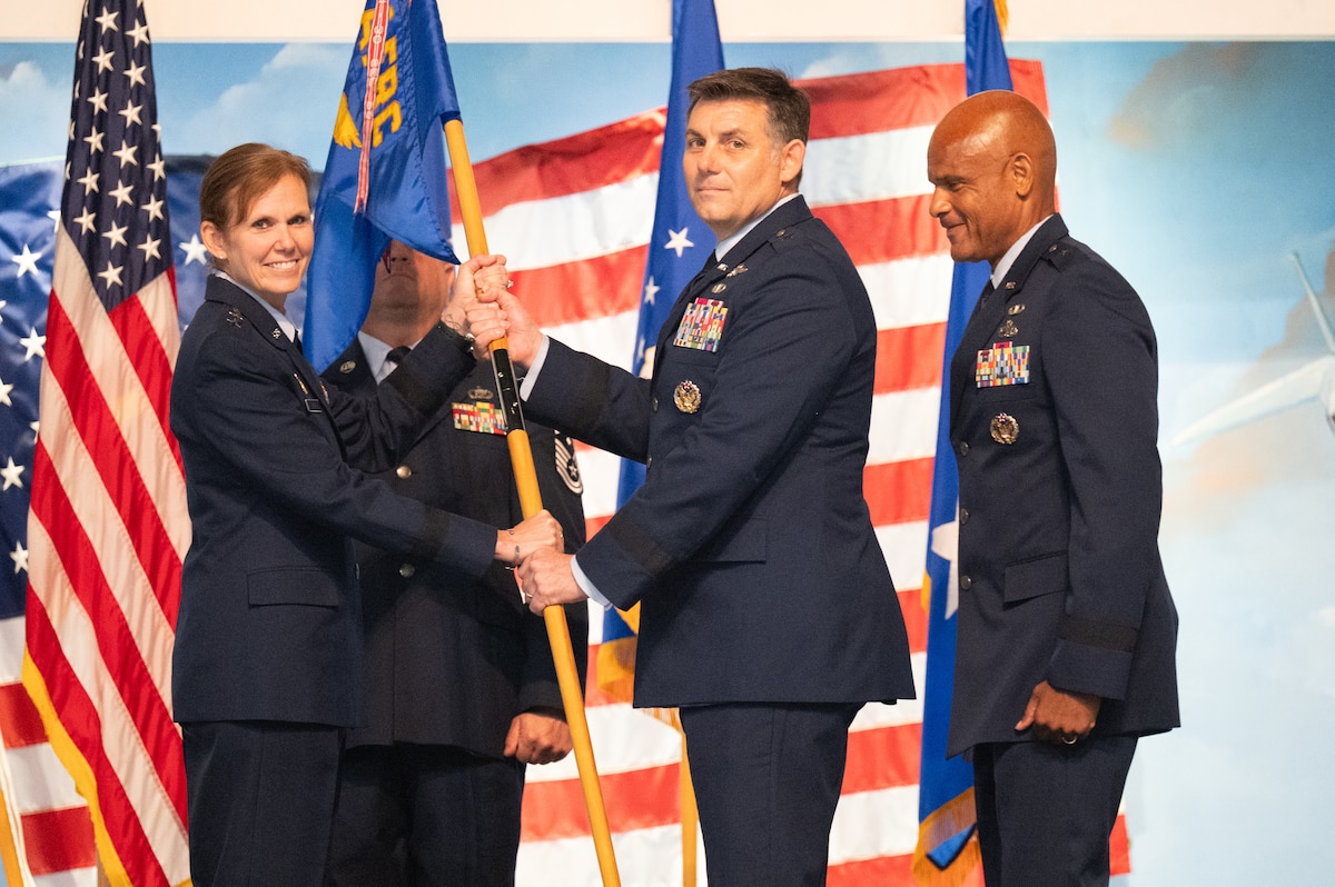Two people standing passing a flag