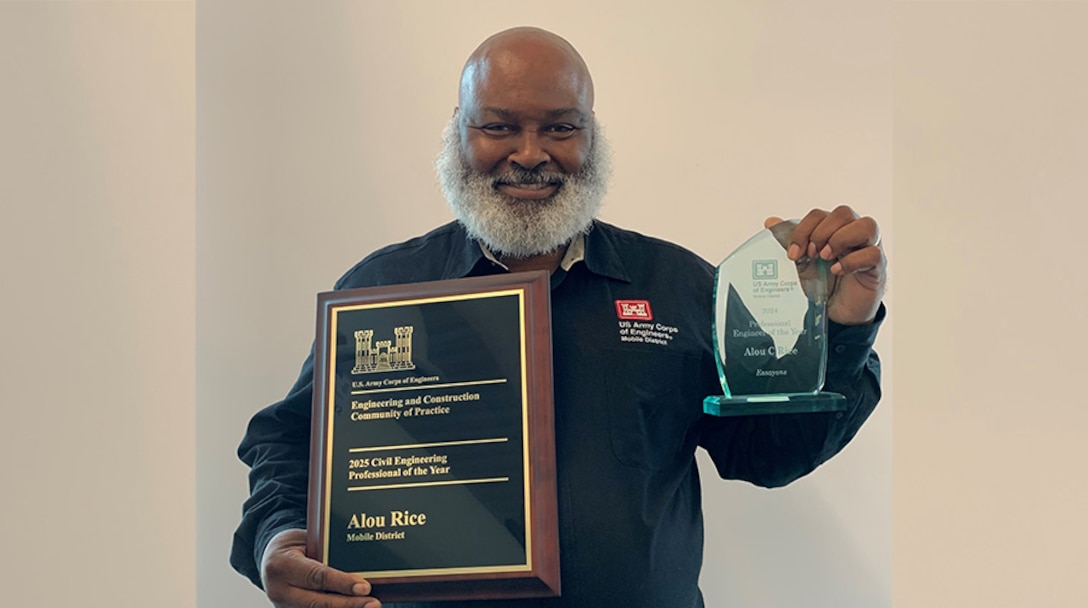 Man holding an Award and plaque