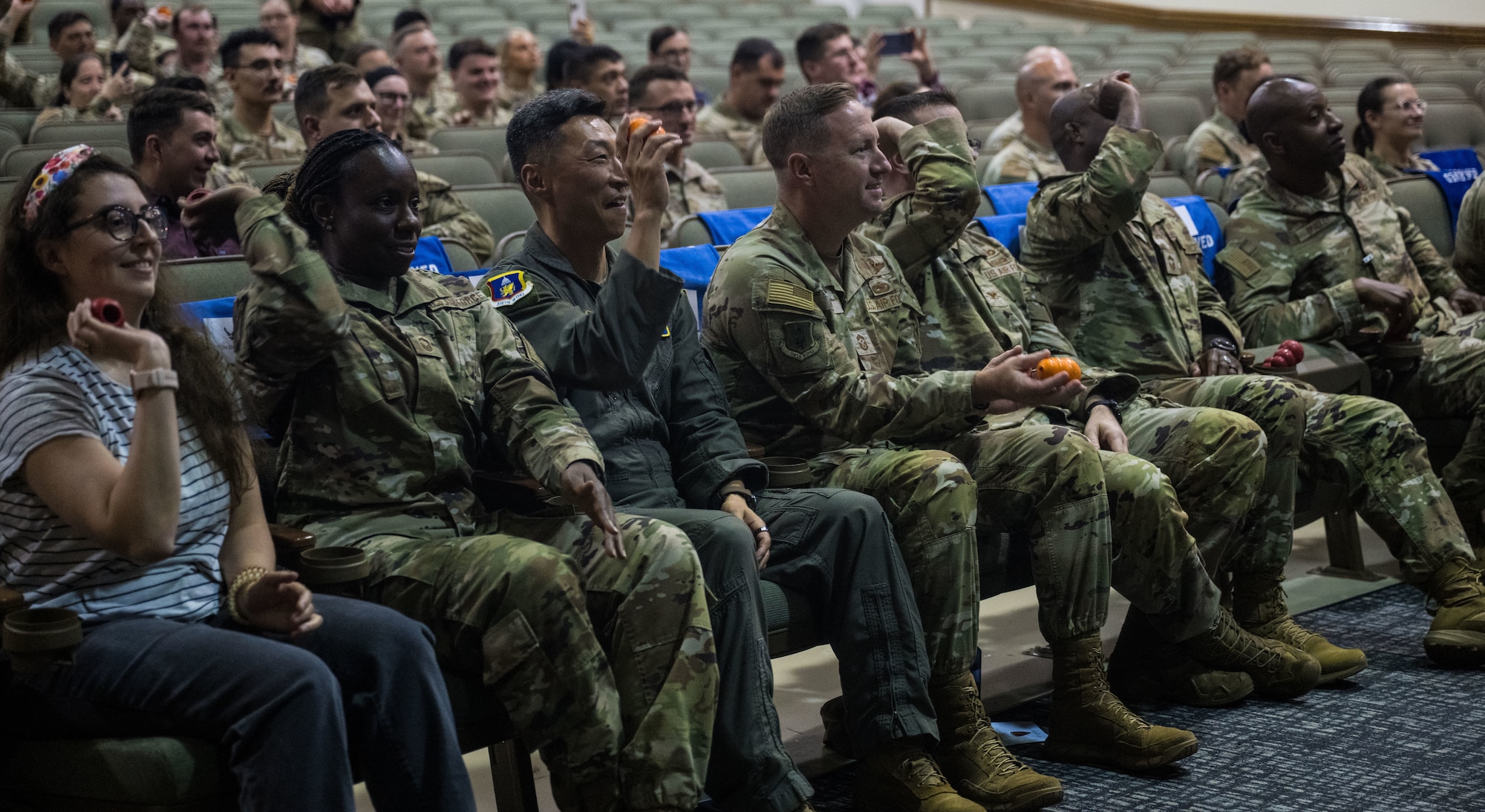 A group of U.S. service members in camouflage uniforms and civilians sit in rows of chairs, some clapping, during the retirement ceremony for military working dogs at Joint Base Andrews, Md., Aug. 6, 2025.