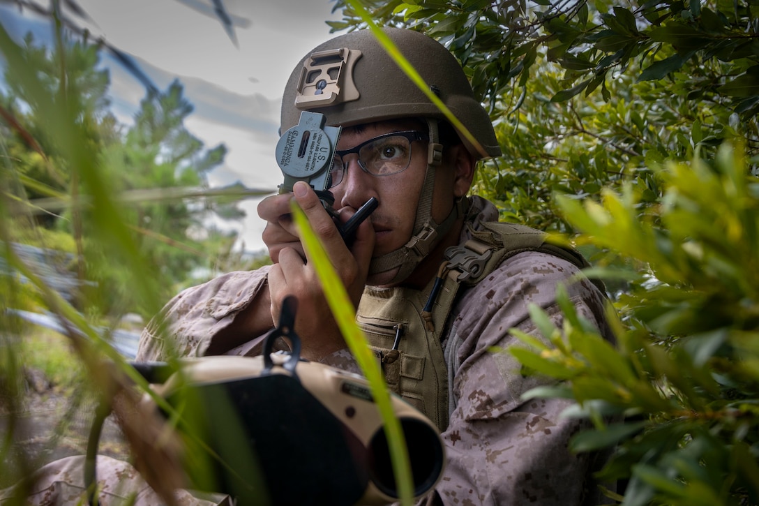 U.S. Marine Corps Cpl. Austin Riveting, a fire support Marine with 4th Air Naval Gunfire Liaison Company, Force Headquarters Group, Marine Corps Forces Reserve, utilizes a lensatic compass during exercise Burmese Chase 25 at Marine Corps Outlying Field Atlantic, North Carolina, July 30, 2025. Burmese Chase is an annual U.S. led, multi-lateral training exercise comprised of integrating ground and air fires, infantry tactics and naval gunfire alongside NATO allies to enhance combat readiness and interoperability. (U.S. Marine Corps photo by Cpl. Adam Scalin)