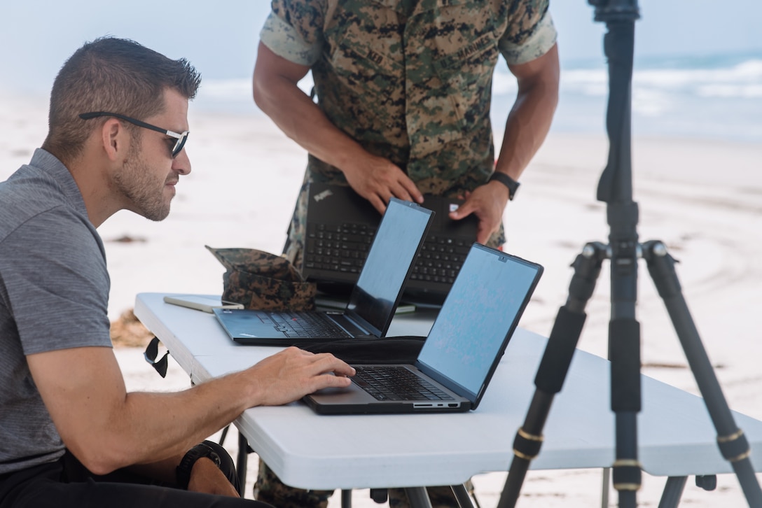Joshua Mickles, a vice president of Jaia Robotics, examines the data of an autonomous underwater vehicle during a JaiaBot familiarization course with U.S. Marines assigned to the 15th Marine Expeditionary Unit, I Marine Expeditionary Force, at Marine Corps Base Camp Pendleton, California, Aug. 5, 2025. These types of unmanned systems enable the 15th MEU to autonomously gather and share high-resolution environmental data in coastal and littoral zones to support reconnaissance, operational planning, and mission success. (U.S. Marine Corps photo by Lance Cpl. Kenneth Twaddell)