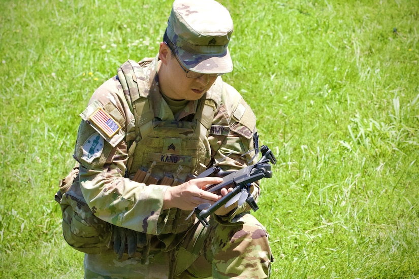 U.S. Army Sgt. Peter Kang, a drone operator with 1st Battalion, 109th Infantry Regiment, 2nd Infantry Brigade Combat Team, 28th Infantry Division, inspects an unmanned aerial system during a demonstration at Fort Indiantown Gap, Pennsylvania, July 28, 2025. The Soldiers and representatives from Carnegie Mellon University’s Software Engineering Institute demonstrated Project Shrike, an AI-enabled system for rapid target recognition and fire adjustment, by integrating drones and artillery during live-fire training. (U.S. Army National Guard photo by Maj. Travis Mueller)