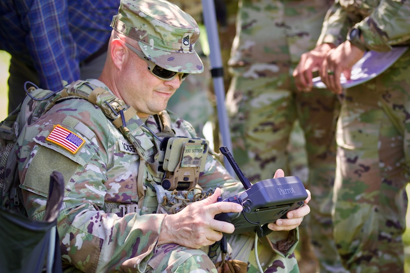 U.S. Army Staff Sgt. Eric Scuderi, a drone operator with 1st Battalion, 109th Infantry Regiment, 2nd Infantry Brigade Combat Team, 28th Infantry Division, remotely flies an unmanned aerial system during a demonstration at Fort Indiantown Gap, Pennsylvania, July 28, 2025. The Soldiers and representatives from Carnegie Mellon University’s Software Engineering Institute demonstrated Project Shrike, an AI-enabled system for rapid target recognition and fire adjustment, by integrating drones and artillery during live-fire training. (U.S. Army National Guard photo by Maj. Travis Mueller)