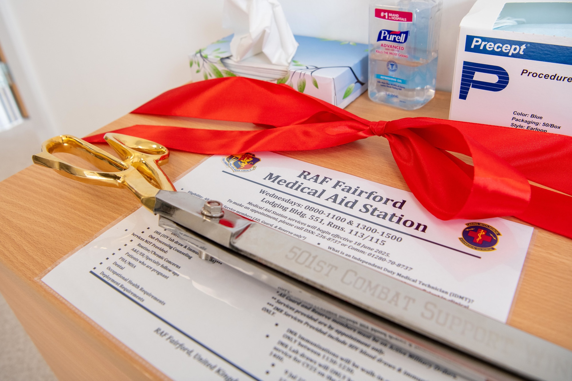 A ceremonial ribbon and scissors rest on a table before the opening of the new medical aid station