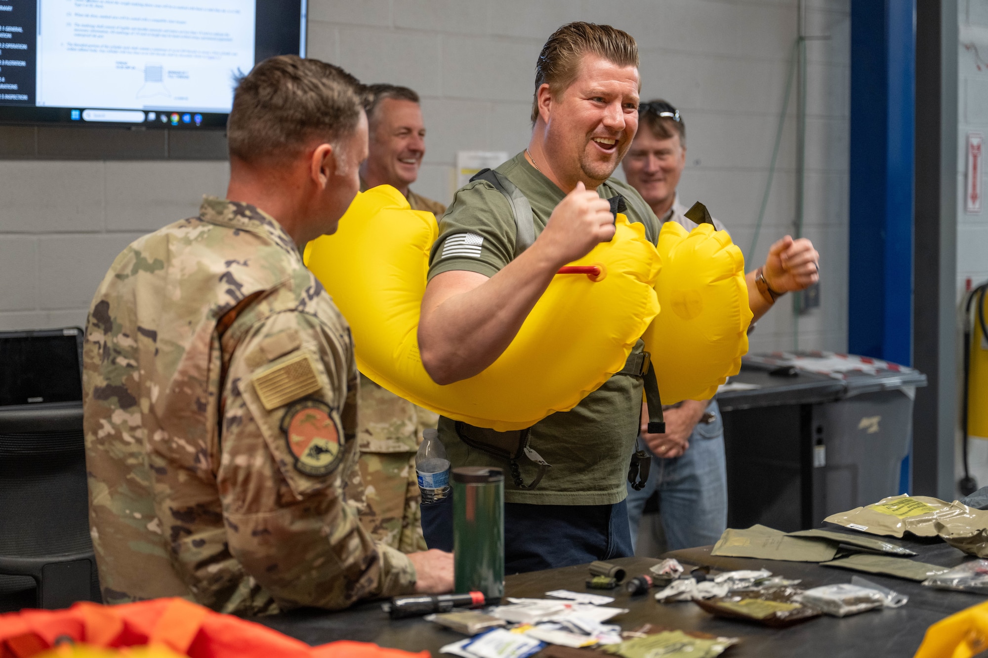 Mr. Mark Pulley, 7th Civil Engineer Squadron honorary commander, learns how to properly use an inflatable flotation device during a water survival demonstration at Dyess Air Force Base, Texas, Aug. 6, 2025. Dyess hosted a tour for Dyess and Goodfellow honorary commanders providing insight into base operations and fostering partnerships between military and local communities. (U.S. Air Force photo by Airman Caleb Schellenberg)