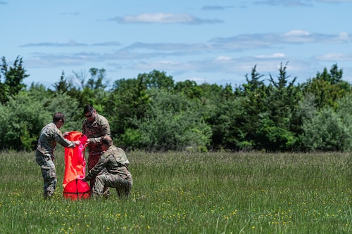 Airmen place high-visibility marker panel down for landing zone