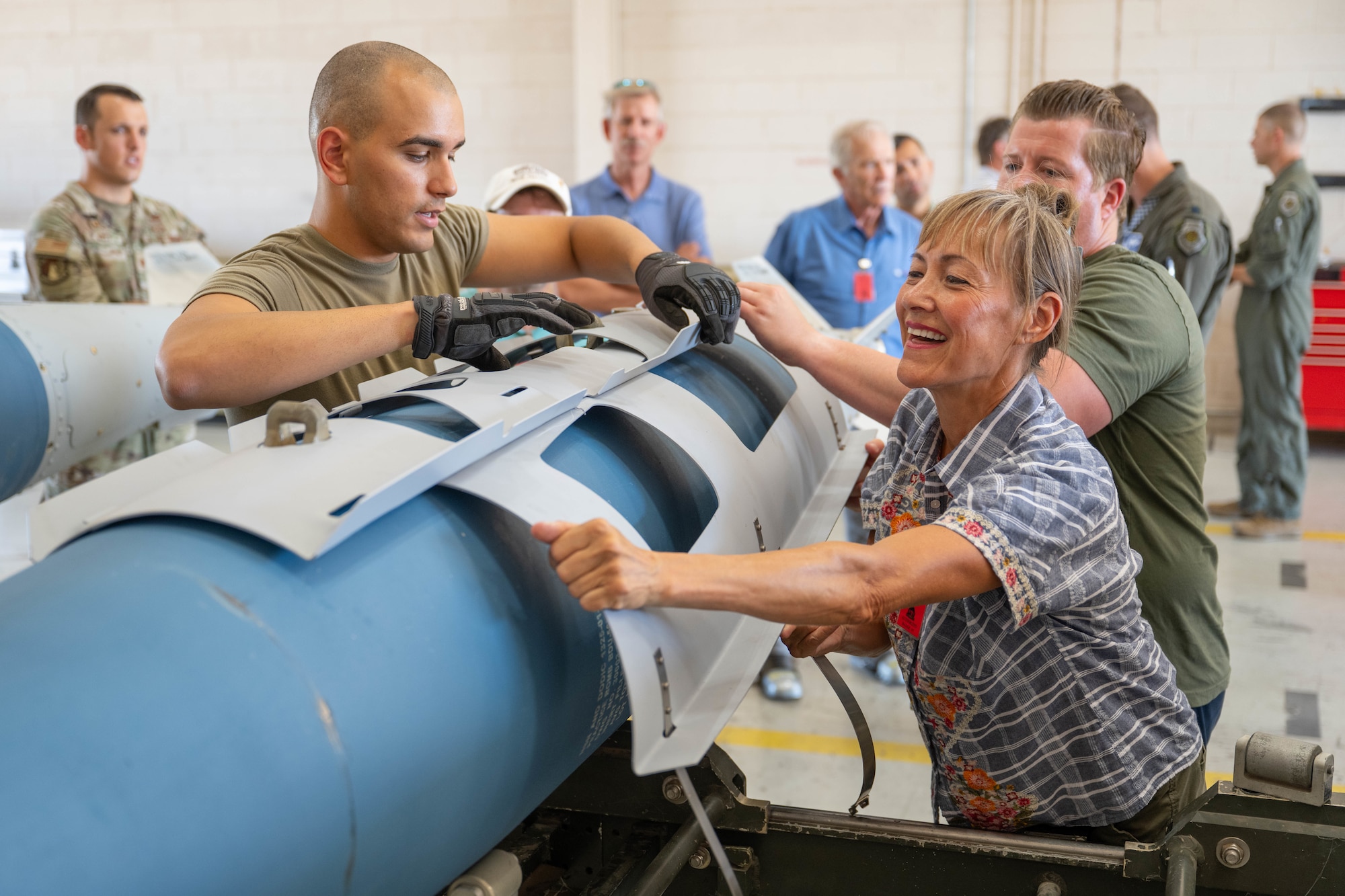 Mrs. Donna Long-Wolfer, 28th Bomber Generation Squadron honorary commander, builds a Joint Direct Attack Munition with assistance from the 7th Munitions Squadron during a tour at Dyess Air Force Base, Texas, Aug. 6, 2025. The Dyess Honorary Commander program also serves as a forum for commanders and civic leaders to exchange ideas on issues impacting military and civilian communities. (U.S. Air Force photo by Airman Caleb Schellenberg)