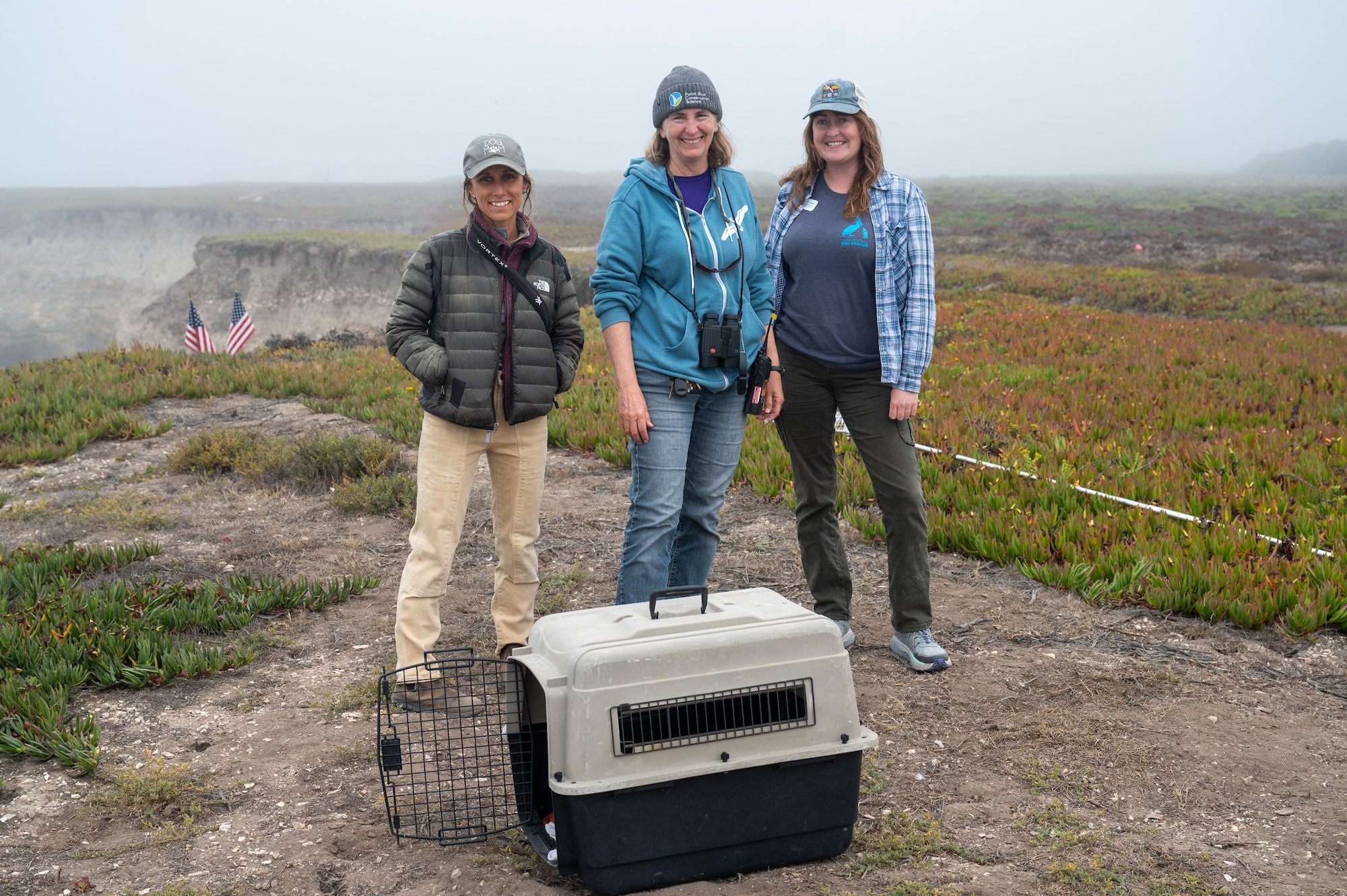 From left to right, Ryanne Pritchard Bee, Santa Barbara Wildlife Care Network, Julie Howar, Point Blue Conservation Science, and Kadi Erickson, International Bird Rescue, celebrate a successful return of four rehabilitated juvenile Pigeon Guillemots to the wild at Vandenberg Space Force Base, Calif, Aug. 6, 2025. The release reflects the power of connected partnerships in protecting California’s coastal ecosystems and marine biodiversity. The Department of the Air Force has been monitoring special status plant and wildlife species at Vandenberg for several decades with launch-specific monitoring occurring since the early 1980’s. Vandenberg has a dedicated environmental team of more than 40 personnel continuing that monitoring process and surveying natural resource resilience.