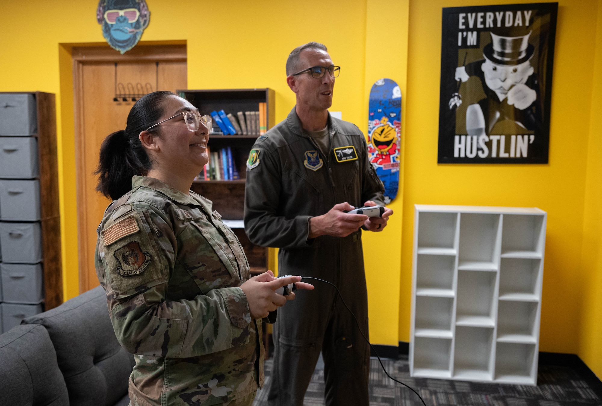 U.S. Air Force Col. Thomas Taylor, 5th Bomb Wing deputy commander, and Senior Airman Keolani Tran Copas, a religious affairs Airman, play a video game after the opening ceremony for the Airmen Ministry Center at Minot Air Force Base, North Dakota, Aug. 8, 2025. The Airmen Ministry Center was created to provide a welcoming environment where Airmen can unwind, connect and engage in activities they enjoy regardless of their position or rank. (U.S. Air Force photo by Airman 1st Class Wesley Davies)