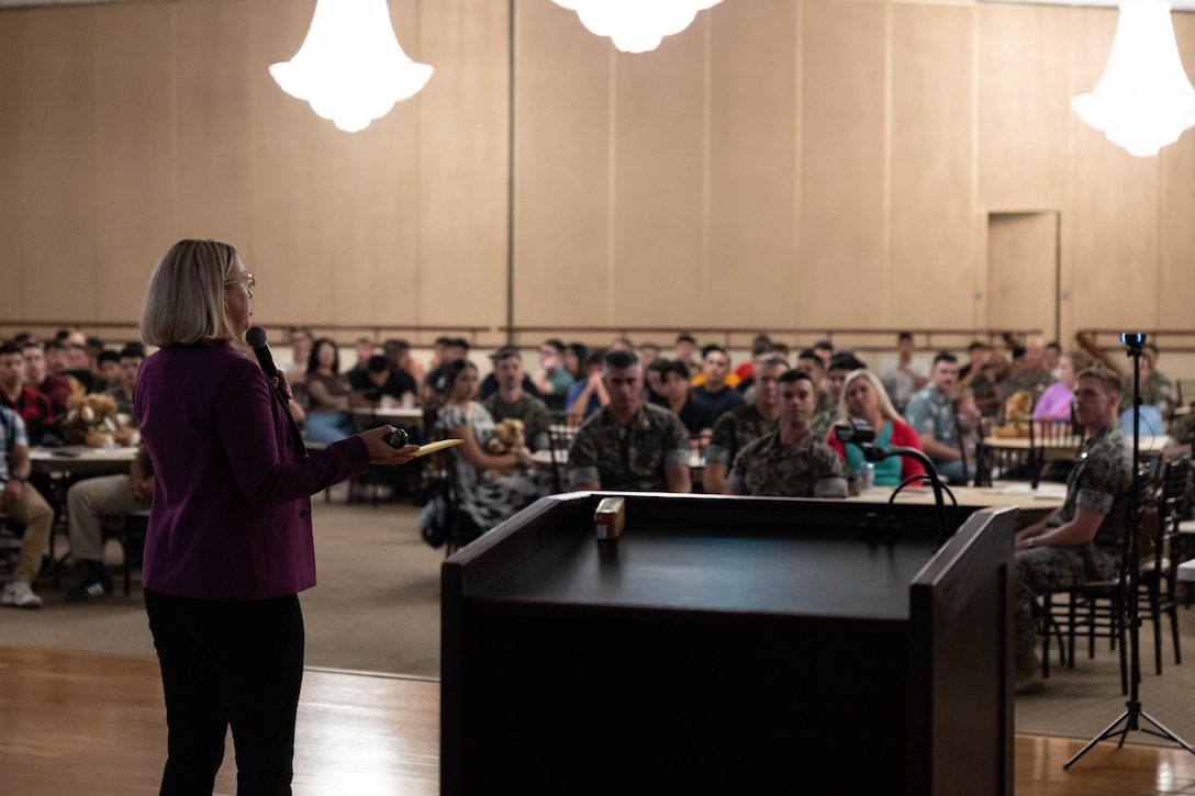 Kyp Hughes, deployment readiness coordinator for the 11th Marine Expeditionary Unit, I Marine Expeditionary Force, speaks to the Marines and families of the 11th MEU during a town hall discussion at Marine Corps Base Camp Pendleton, California, Aug. 6, 2025. The town hall aimed to foster esprit-de-corps while informing Marines and their families about the resources and support available through the 11th MEU. (U.S. Marine Corps photo by Lance Cpl. Luke Rodriguez)