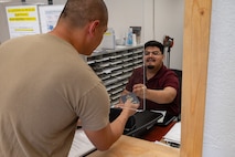 A person providing customer service to another person at a counter