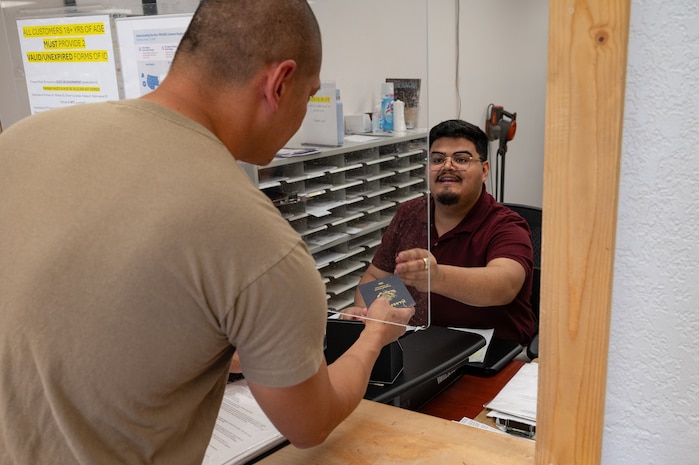 A person providing customer service to another person at a counter