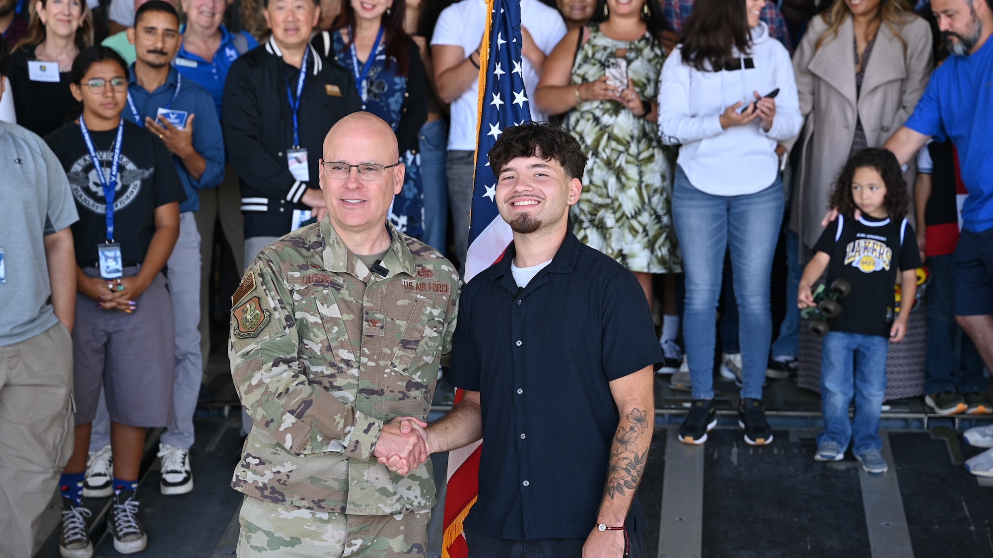 Col. Cade C. Gibson, left, commander of the 349th Maintenance Group, shakes hands with new recruit Shaun Ian Rodriguez after an oath of enlistment ceremony during the Travis Air Reserve Experience at Travis Air Force Base, Calif., Aug. 3, 2025. The Travis Air Reserve Experience is a recruiting event designed to give community members an opportunity to interact directly with Reserve Airmen, learn about career paths, and explore the mission of the 349th Air Mobility Wing.
