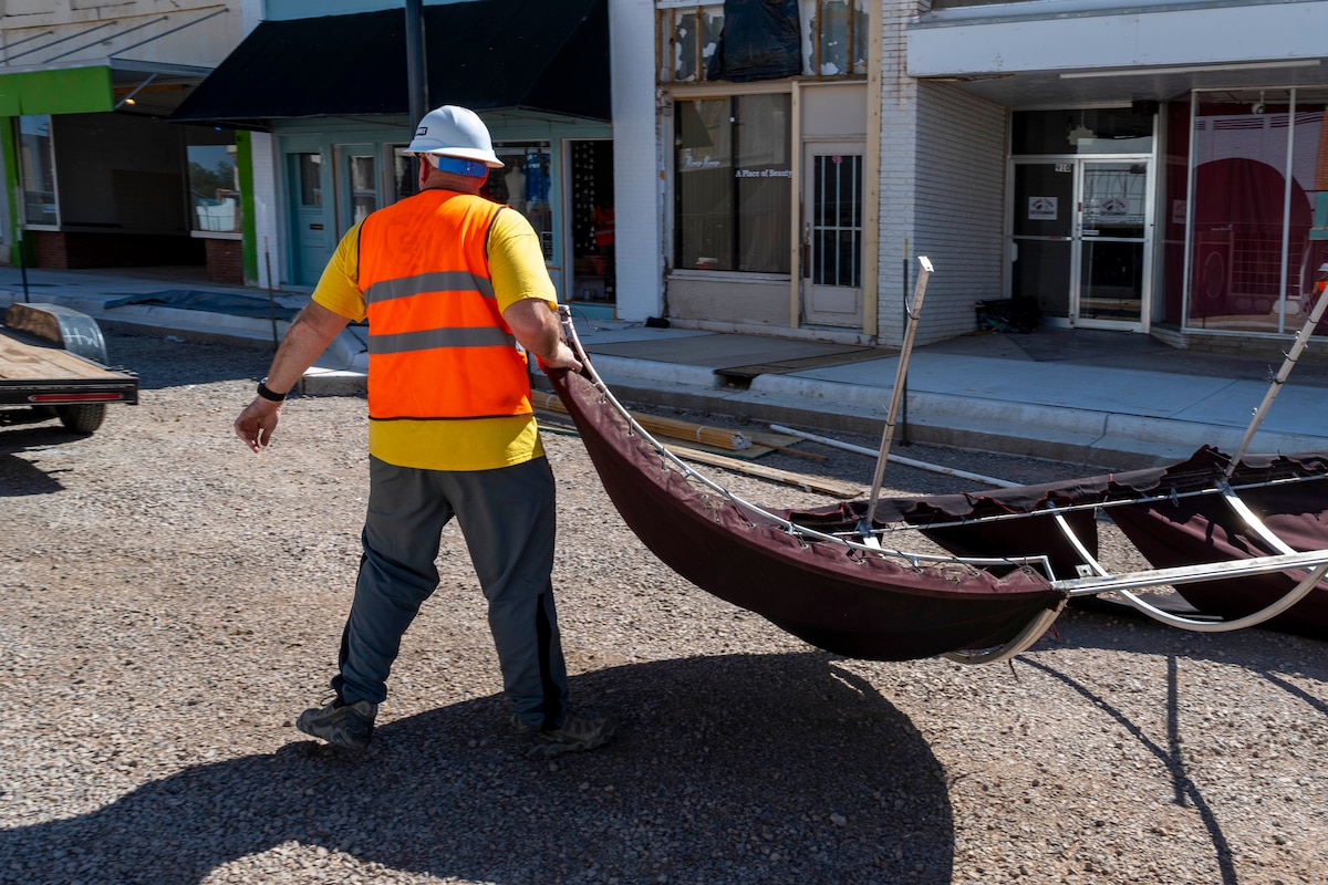 U.S. Air Force Master Sgt. Derrick Glover, 54th Operation Support Squadron radar and weather systems section chief, helps move a torn-down awning at Alamogordo, New Mexico, July 25, 2025.