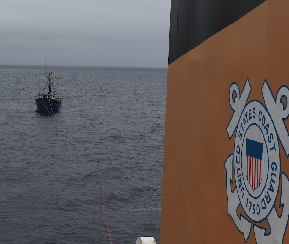 A fishing vessel is seen being towed by the Coast Guard Cutter Alder.
