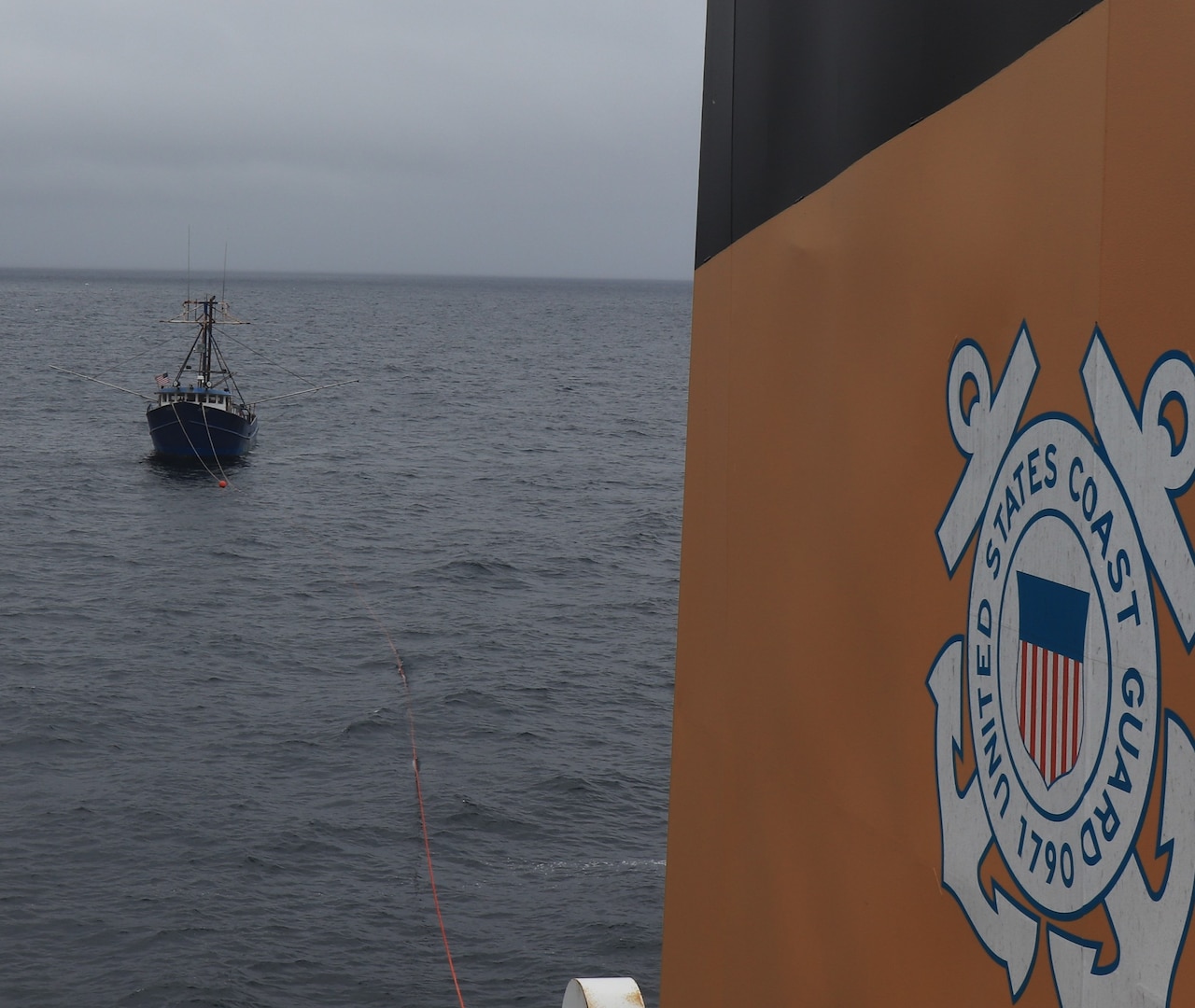 A fishing vessel is seen being towed by the Coast Guard Cutter Alder.