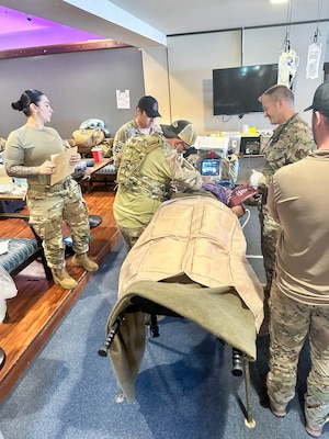 Service members treating simulated patient.
