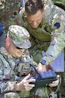 U.S. Army Staff Sgt. Eric Scuderi, left, a drone operator with 1st Battalion, 109th Infantry Regiment, 2nd Infantry Brigade Combat Team, 28th Infantry Division, remotely flies an unmanned aerial system during a demonstration at Fort Indiantown Gap, Pennsylvania, July 28, 2025. The Soldiers and representatives from Carnegie Mellon University’s Software Engineering Institute demonstrated Project Shrike, an AI-enabled system for rapid target recognition and fire adjustment, by integrating drones and artillery during live-fire training. (U.S. Army National Guard photo by Maj. Travis Mueller)