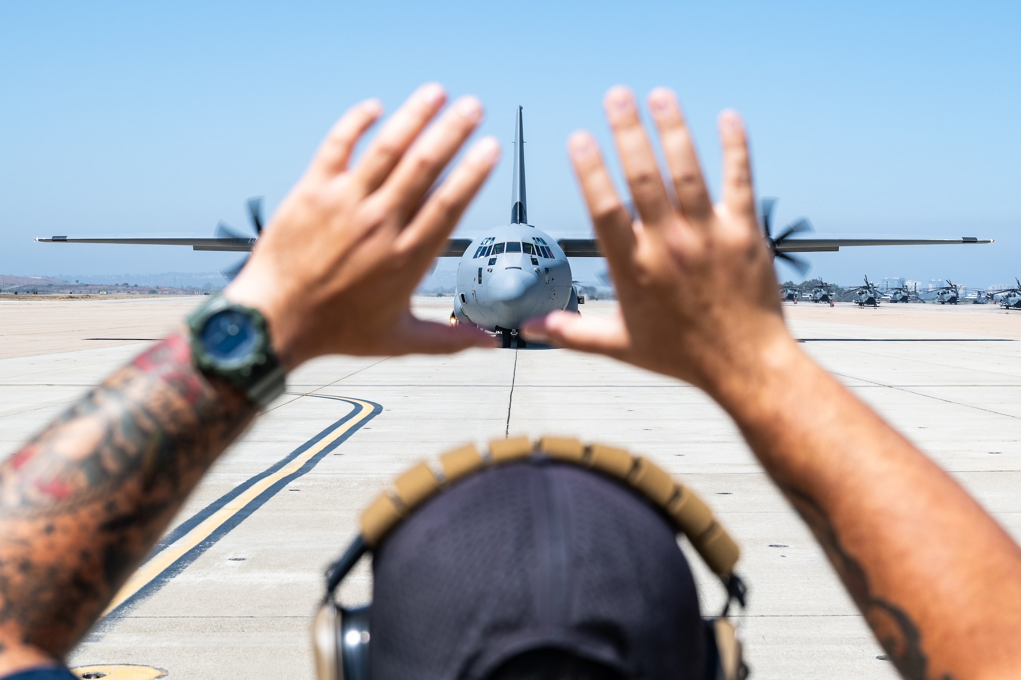 Airman stands in front of plane.