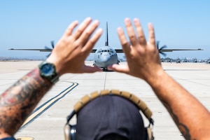 Airman stands in front of plane.