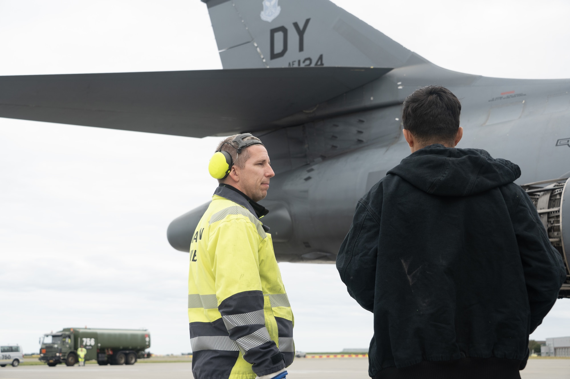 2 men standing by a jet