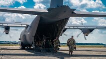 U.S. Airmen from various installations assigned to the 22nd Air Task Force disembark a C-130J Super Hercules assigned to the 815th Airlift Squadron, on the flight line during Exercise Northern Strike 25-2 (NS 25-2) at Battle Creek Air National Guard Base, Michigan, Aug. 8, 2025.